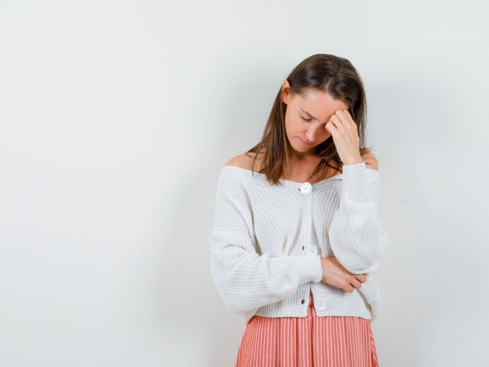 Fiatal nő fájdalmat érez a has környékén.